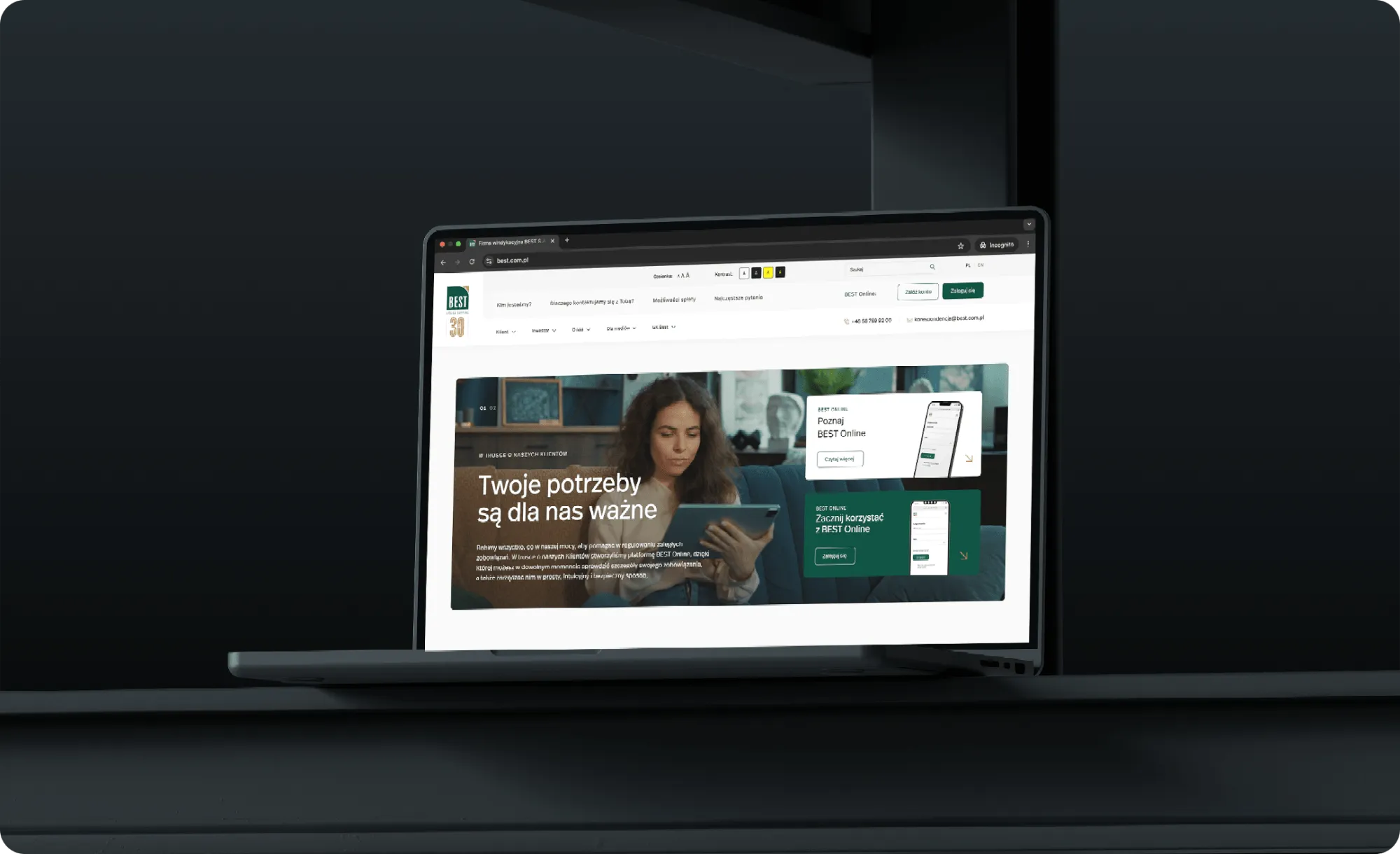 Laptop na ciemnym tle ze stroną główną best.com.pl i hasłem „Twoje potrzeby są dla nas ważne”.