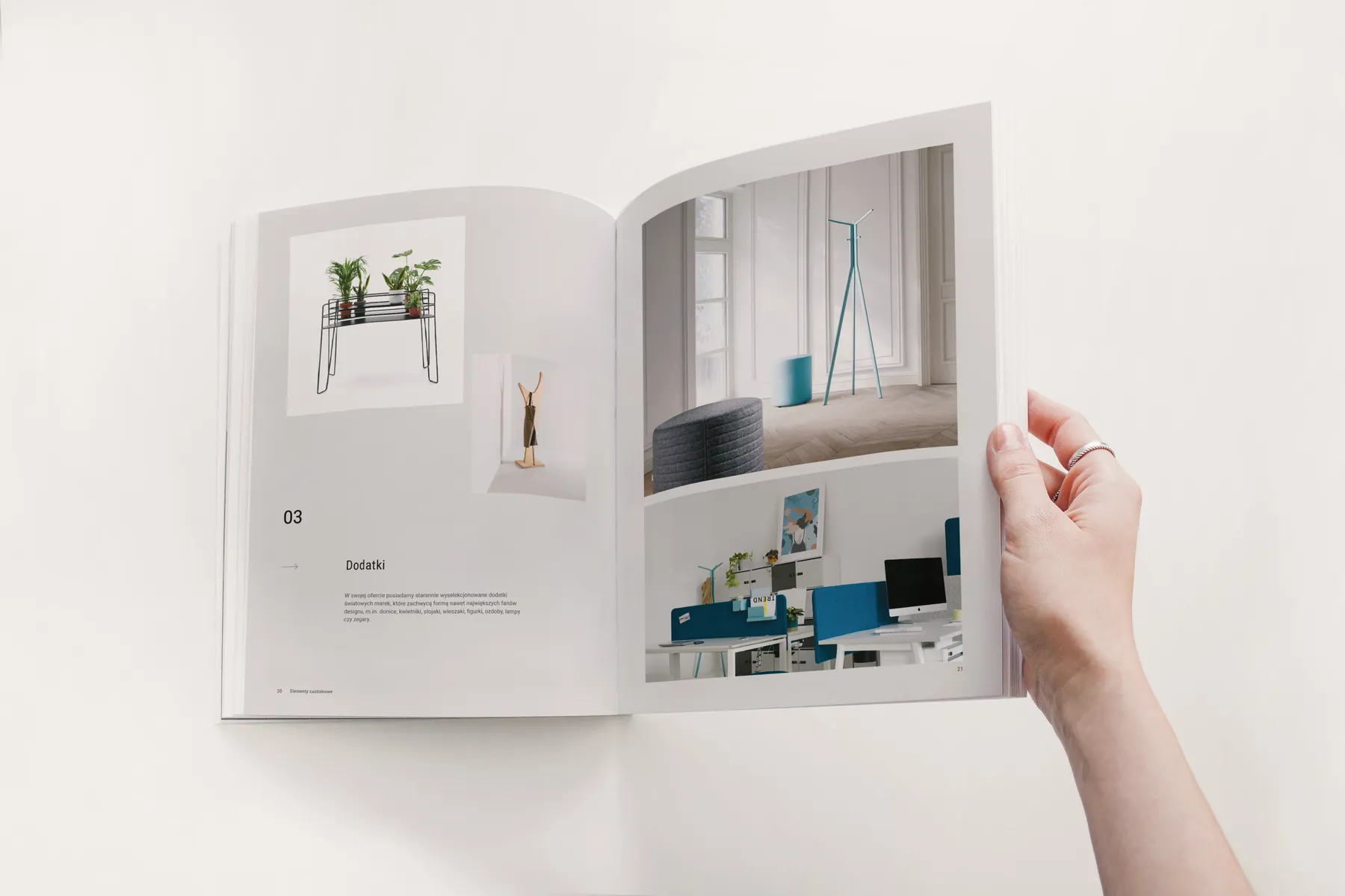 Otwarty katalog Hana Design trzymany w dłoni, rozkładówka z aranżacją biura.