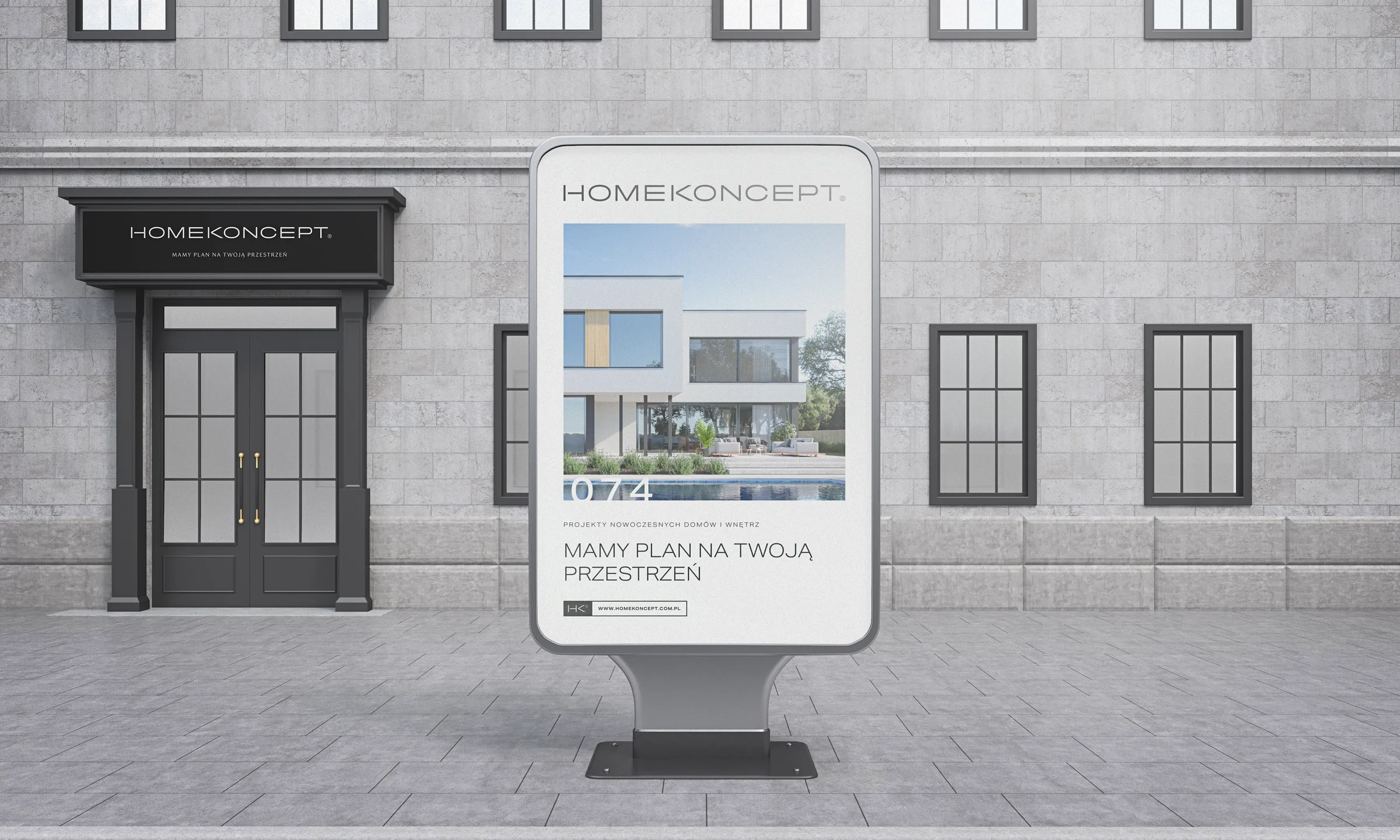 Plakat HomeKoncept z hasłem „Mamy plan na Twoją przestrzeń” w stojaku citylight przed kamienicą.