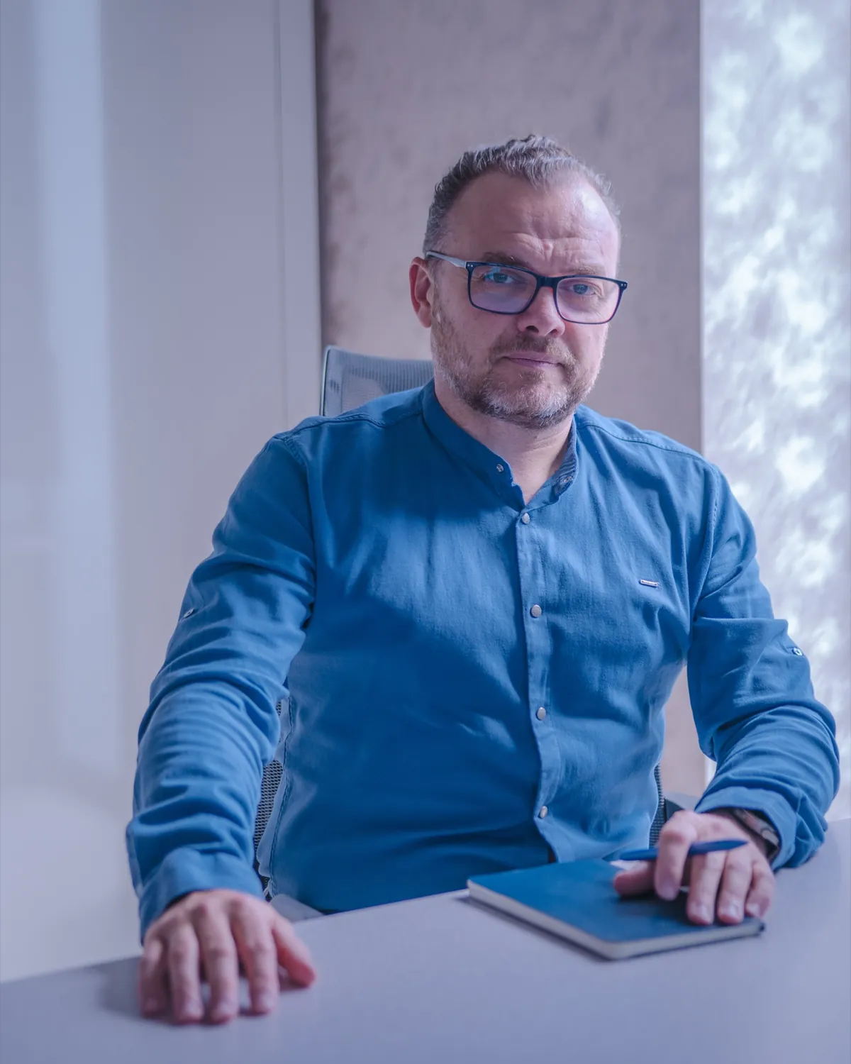 Doktor Tomasz Basta przy biurku w gabinecie Intima Clinic