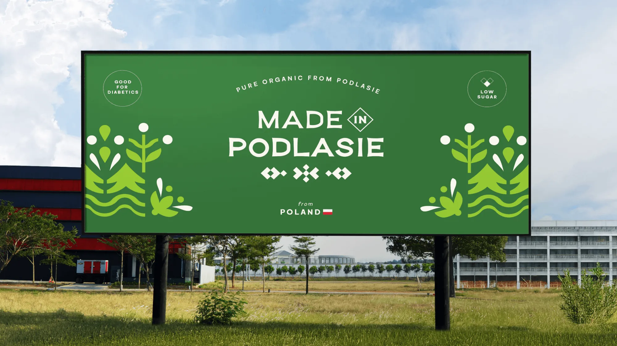 Billboard Made in Podlasie przy drodze: logo, ornament i ilustracje roślin na zielonym tle.