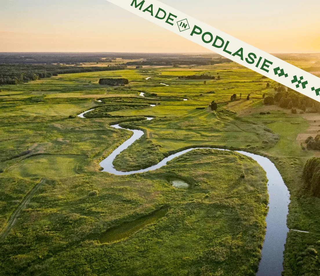 Meandrująca rzeka wśród podlaskich łąk, w rogu taśma z logo Made in Podlasie.