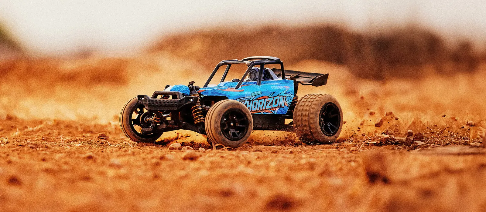 Niebieski buggy X-Horizon w pustynnym kurzu