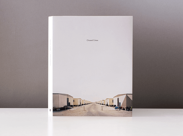 Album „Closed Cities” z białą okładką i zdjęciem osiedla parterowych domów
